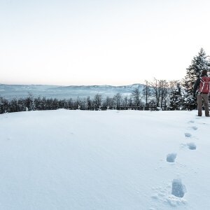 Ein Mann im Schnee. Im Vordergrund seine Fußstapfen.
